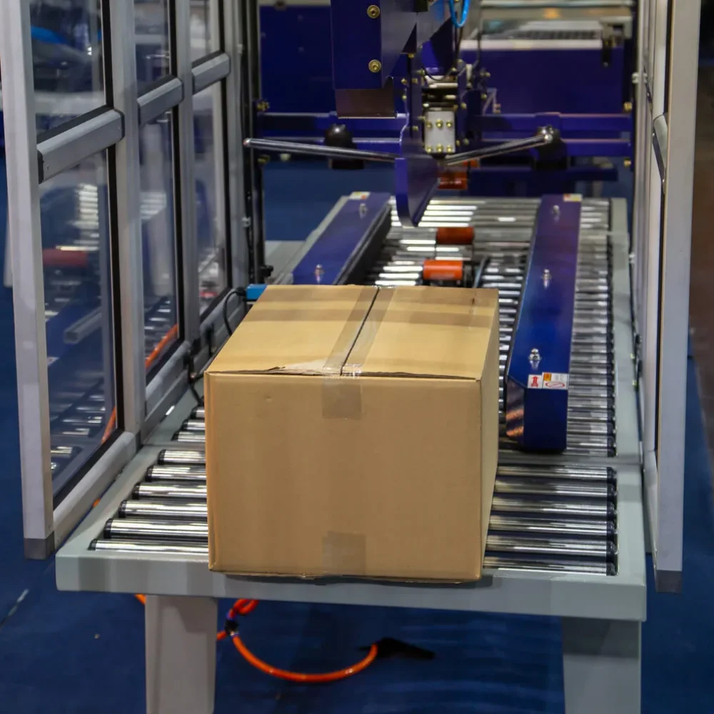 Máy dán thùng carton là thiết bị dùng để dán kín miệng thùng carton bằng băng keo một cách nhanh chóng, chính xác và đồng đều thay cho phương pháp thủ công truyền thống